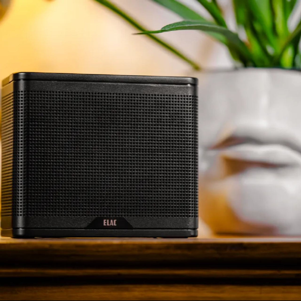 ELAC NAVA 100 Bluetooth Lautsprecher – Schwarz auf einer Kommode