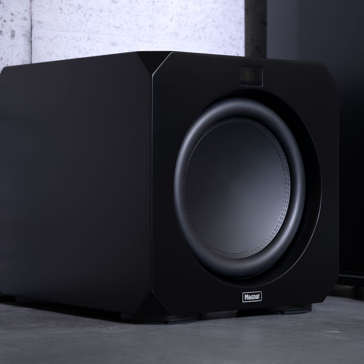 Magnat Omega CS 12 Aktiv-Subwoofer in Seidenmatt Schwarz im Wohnraum