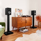 Polk Monitor XT15 Regallautsprecher (Paar) auf Ständern neben einer Holzkommode im Wohnzimmer