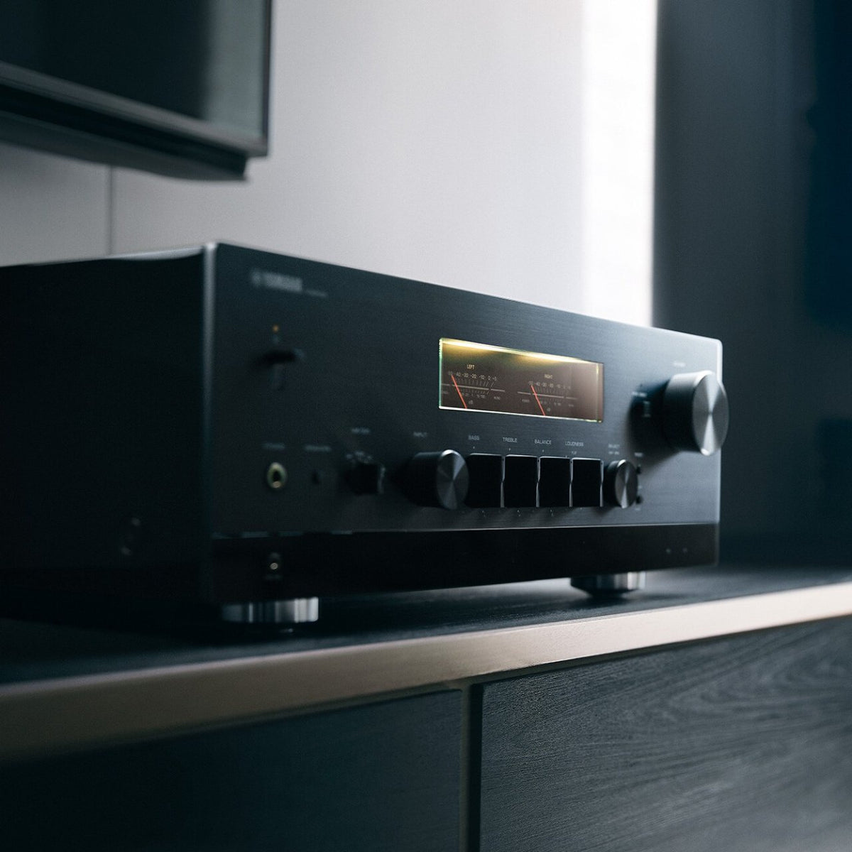 Yamaha R-N2000A - Netzwerk Hi-Fi-Receiver – Front mit Pegelanzeigen neben einem Standlautsprecher